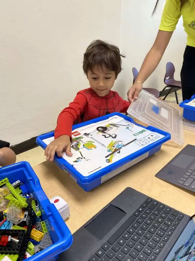 Estudiante concentrado explorando un kit de robótica LEGO