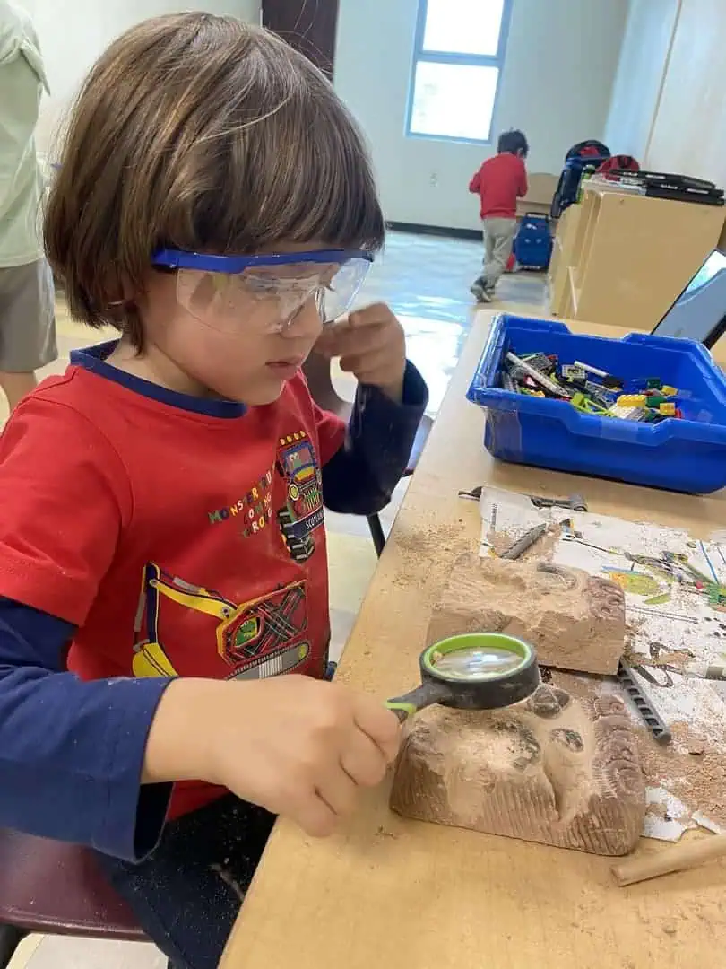 Estudiante con lentes de seguridad realizando un experimento de ciencias